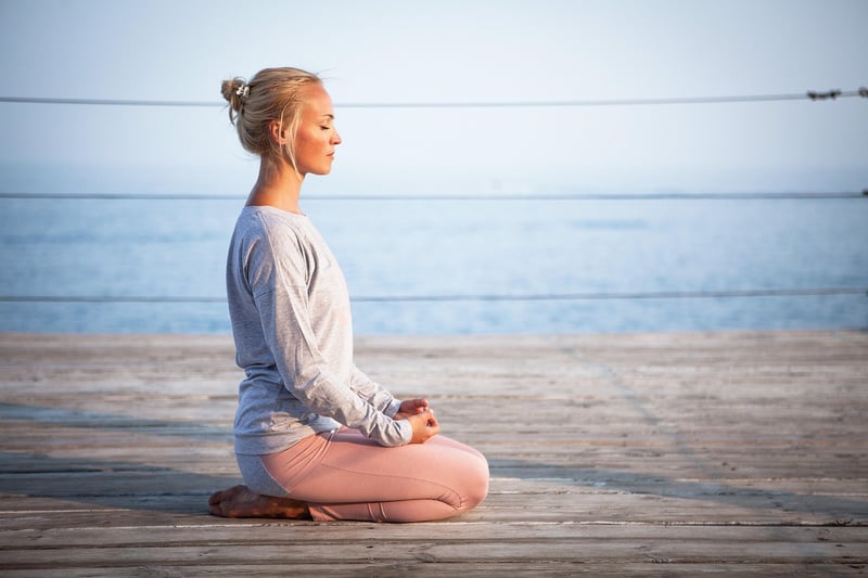 Woman practicing yoga and meditation at sunrise